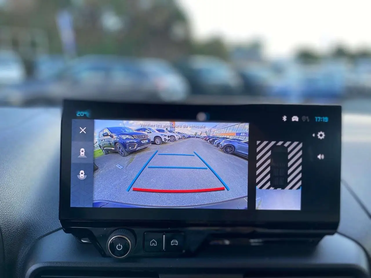 Écran tactile intérieur montrant la caméra de recul avec vue arrière et lignes de guidage du Citroën Berlingo bleu 2025.