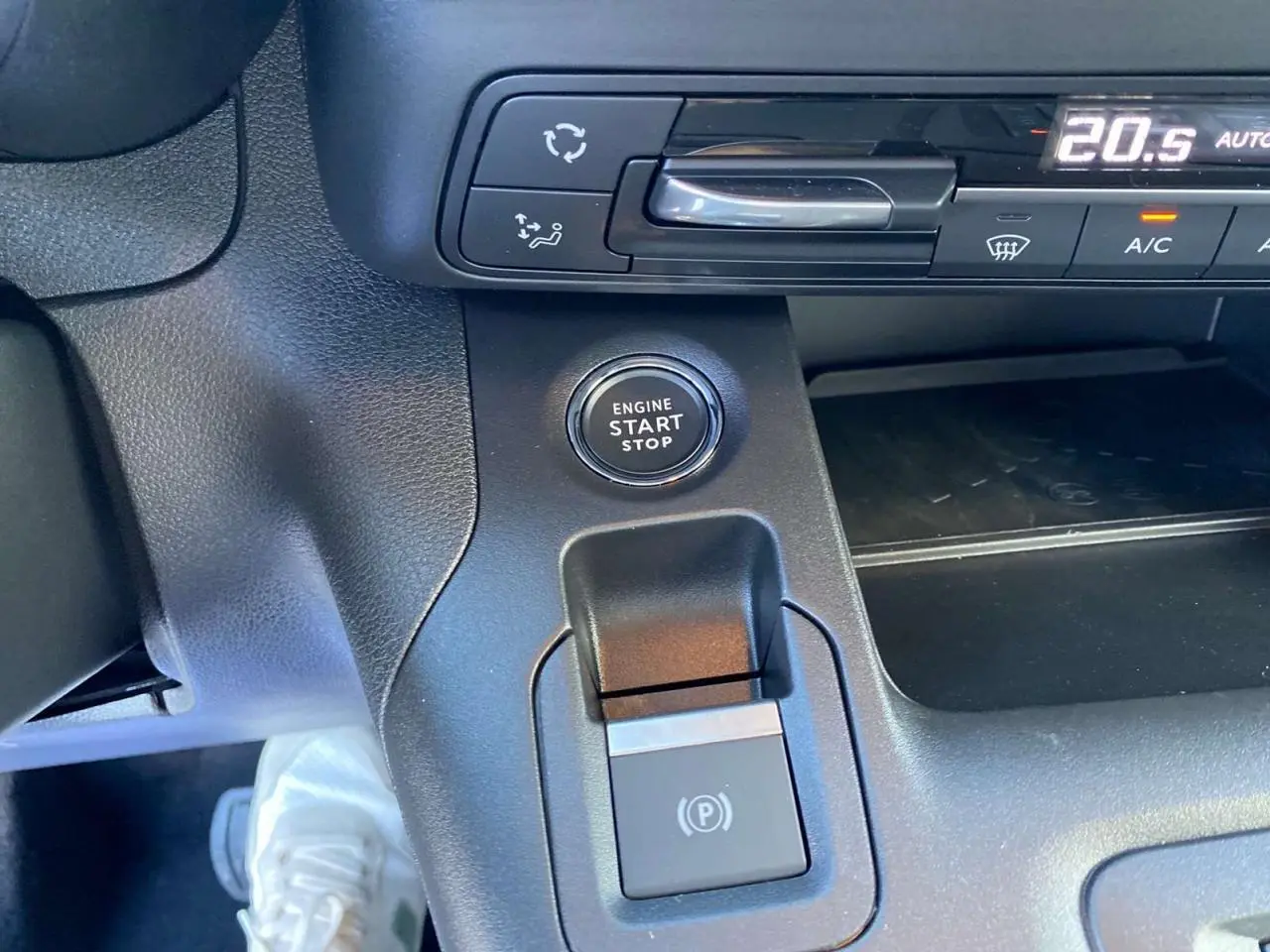 Détail du bouton start/stop et frein électrique sur la console centrale noire du Citroën Berlingo 2025.