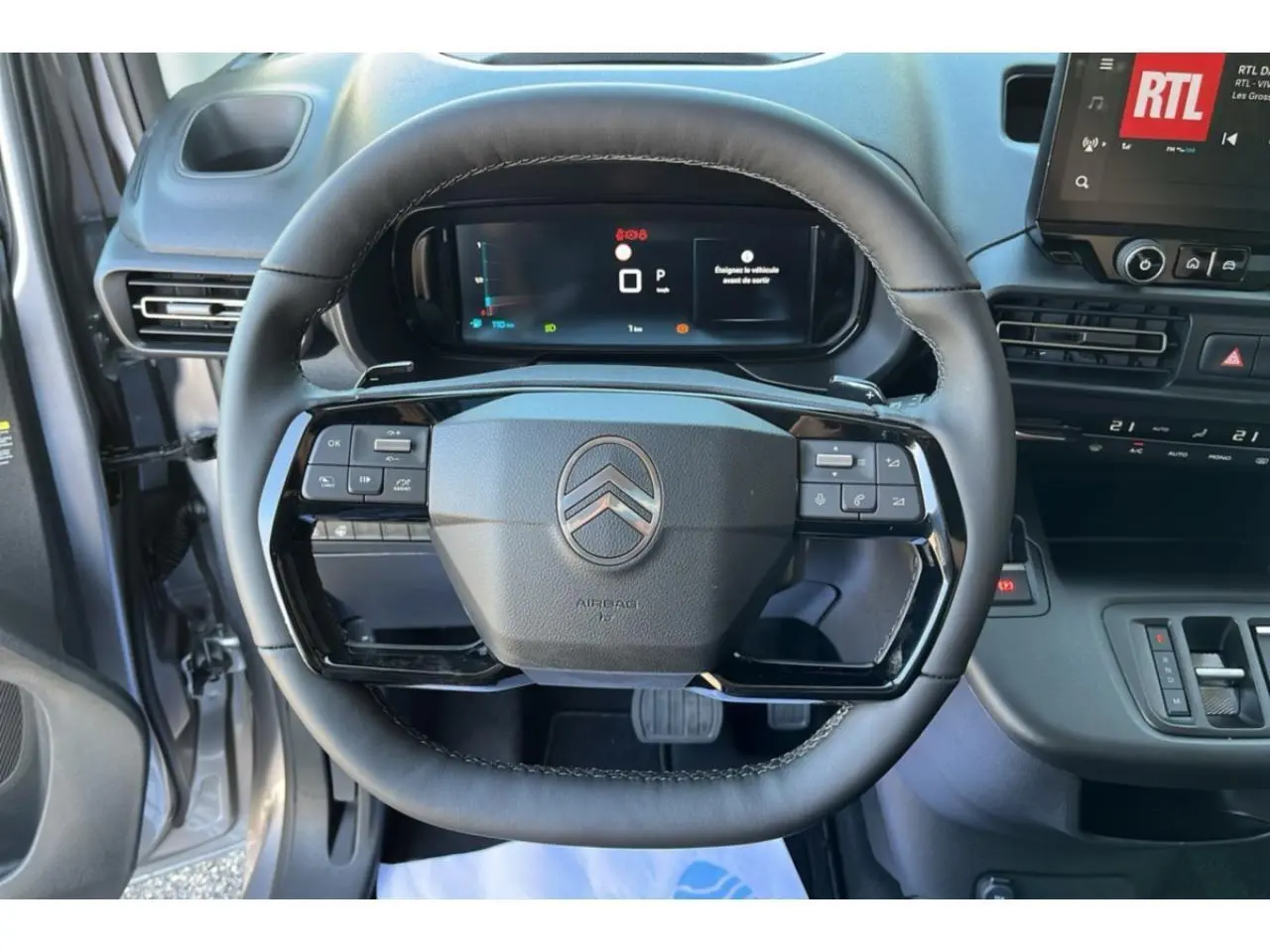 Vue rapprochée du volant cuir noir du Citroën Berlingo 2025 avec commandes intégrées et combiné numérique.