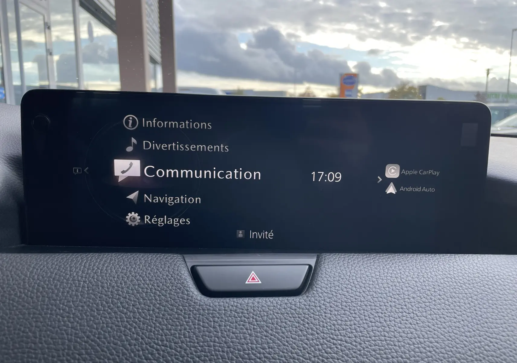 Écran central du tableau de bord du Mazda CX-60 blanc nacré, affichant le menu communication avec Apple CarPlay et Android Auto.