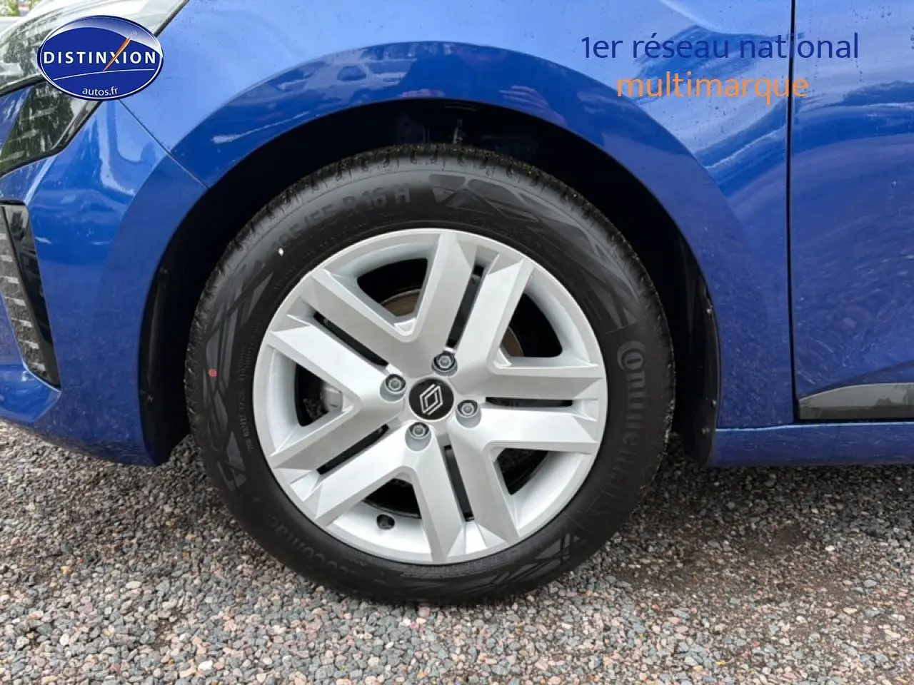Gros plan sur la roue avant gauche d'une Renault Clio V bleu iron avec jante en alliage et logo Renault central.