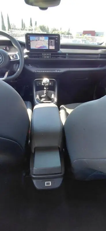 Vue intérieure avant du Jeep Avenger 2025 blanc, montrant la console centrale avec boîte manuelle et écran tactile.