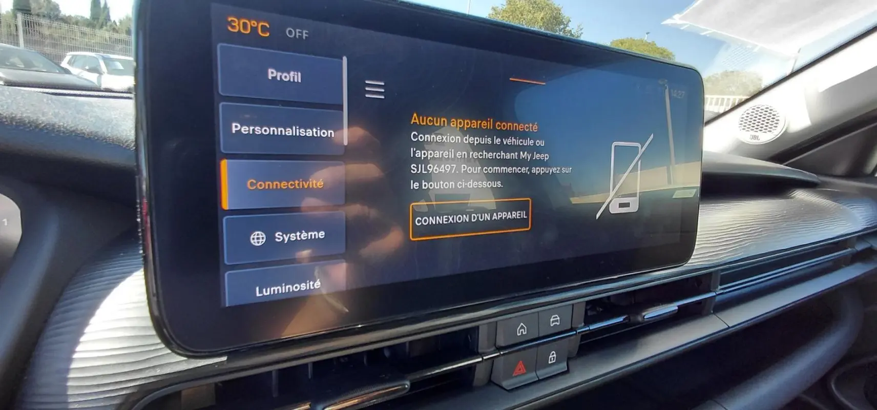 Écran tactile central du Jeep Avenger 2025 blanc, affichant le menu connectivité avec haut-parleur JBL visible.