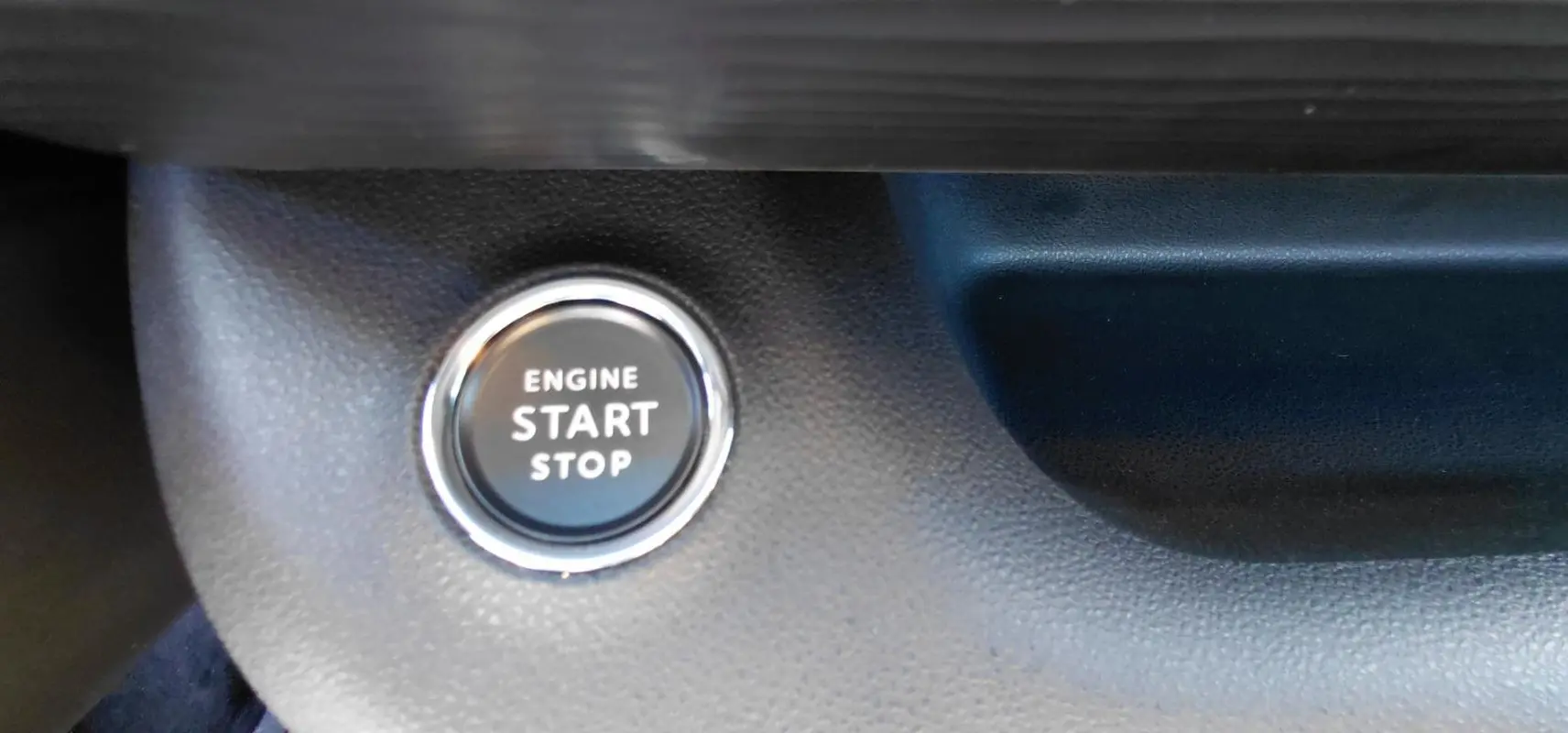 Bouton moteur start/stop en gros plan sur tableau de bord noir du Jeep Avenger blanc 2025, version Altitude.