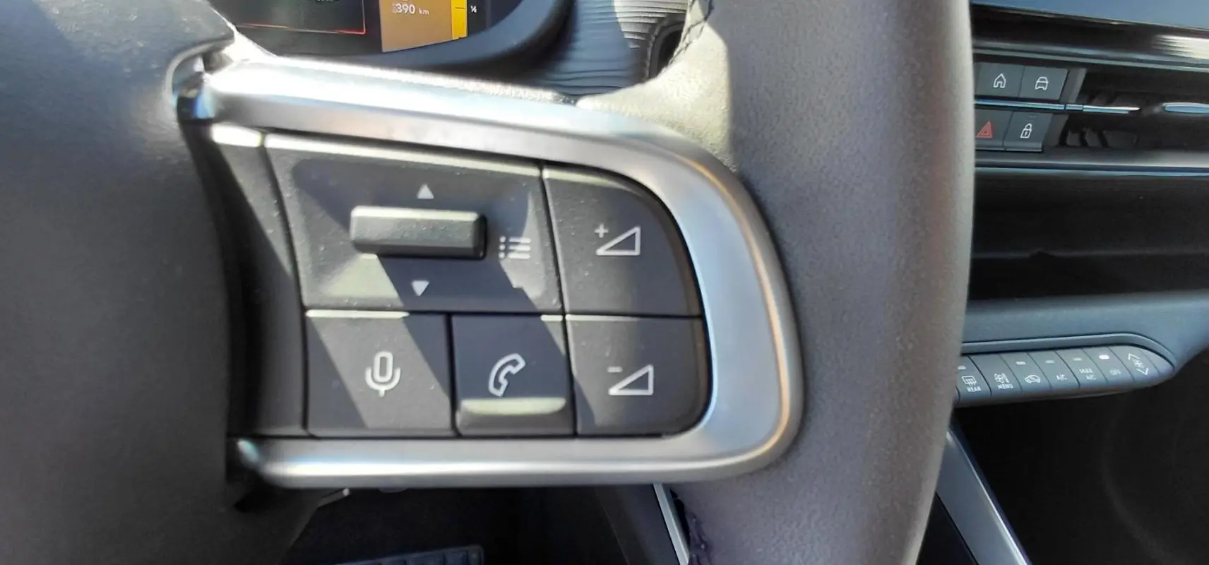 Gros plan sur les commandes au volant côté gauche du Jeep Avenger blanc 2025, avec boutons de volume et appels.