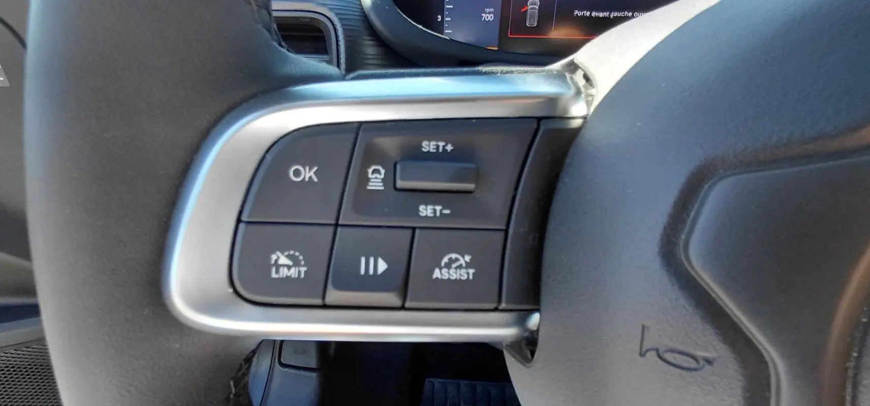 Gros plan sur les commandes de régulateur de vitesse au volant du Jeep Avenger blanc 2025, version Altitude.
