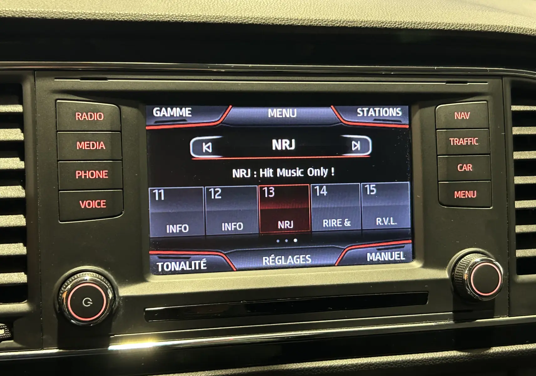 Écran central de la SEAT LEON 1.4 TSI 2014 affichant la radio NRJ avec commandes tactiles et boutons autour.