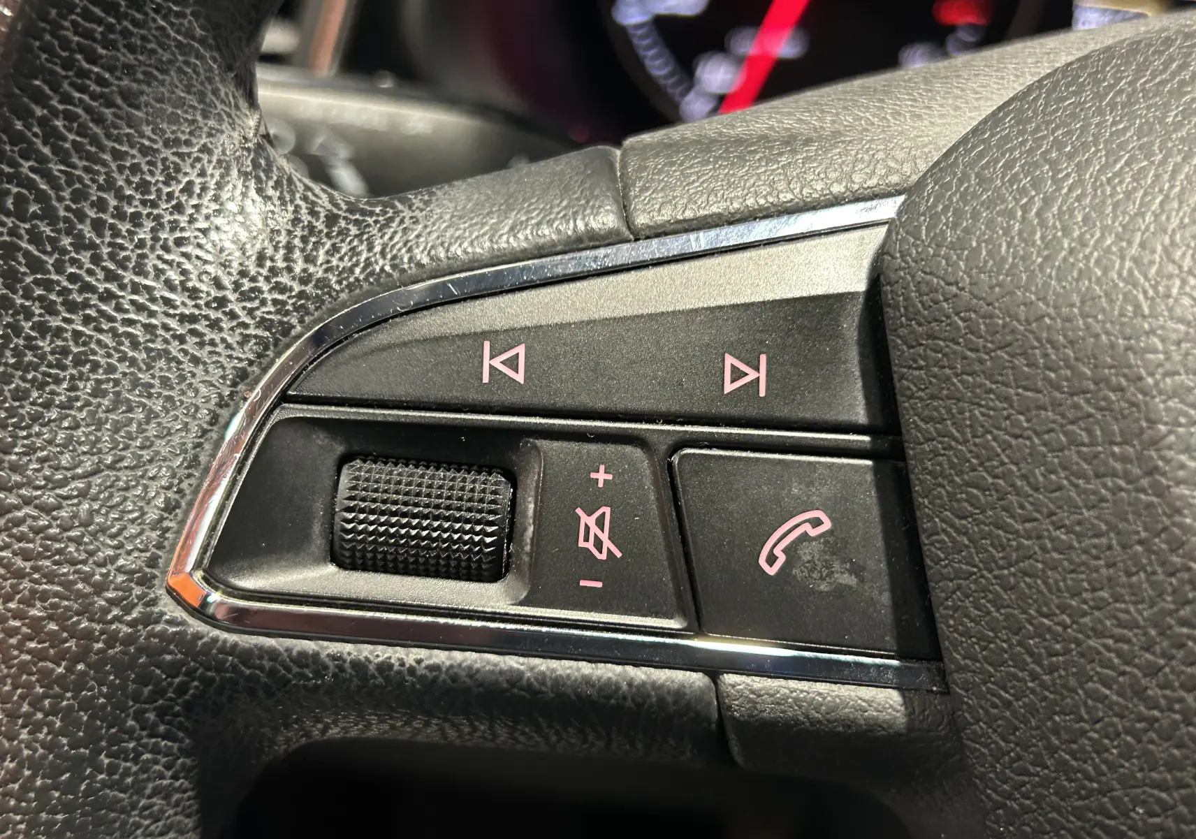Gros plan sur les commandes audio et téléphone au volant en cuir noir du SEAT Leon 2014, version Style.