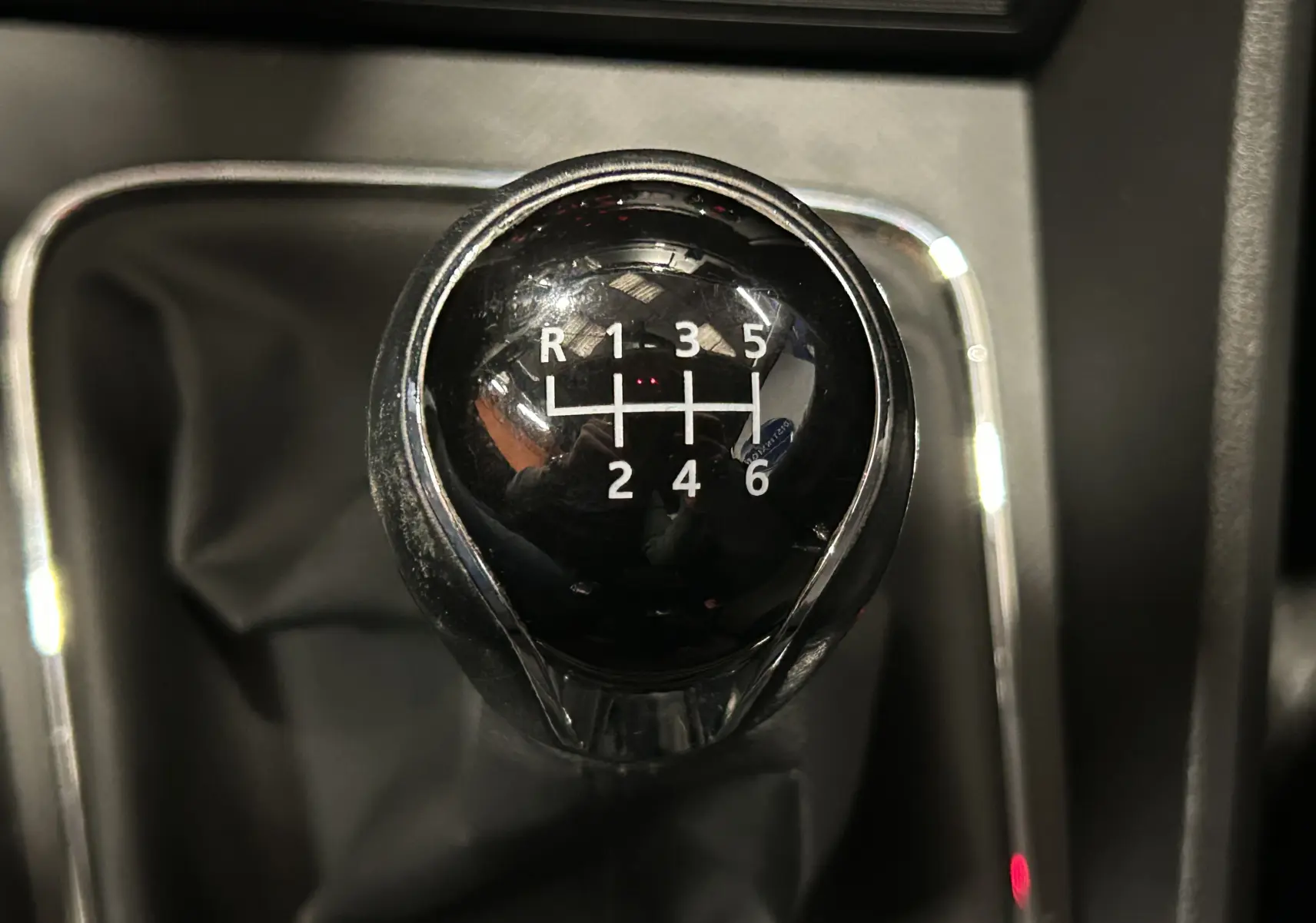 Gros plan sur le levier de vitesses noir de la SEAT LEON 1.4 TSI 122ch, boîte manuelle 6 rapports, avec marquages blancs.