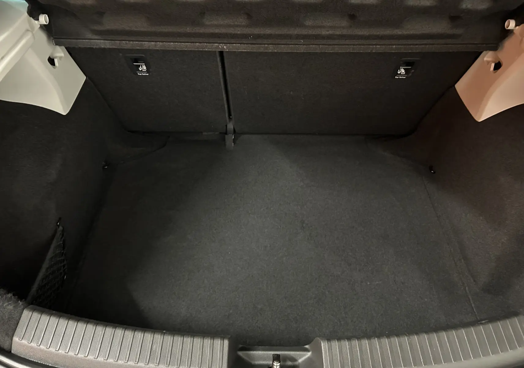Coffre vide vu de face d'une SEAT Leon 2014 noir, avec revêtement tissu noir et habillage intérieur sobre.