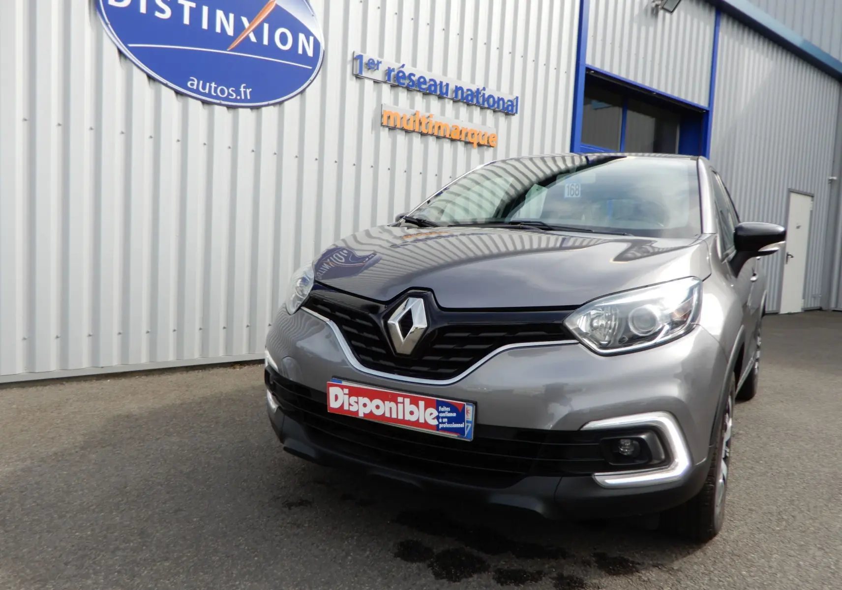 Renault Captur gris cassiopée vu en 3/4 avant droit, avec phares LED et calandre noire brillante.