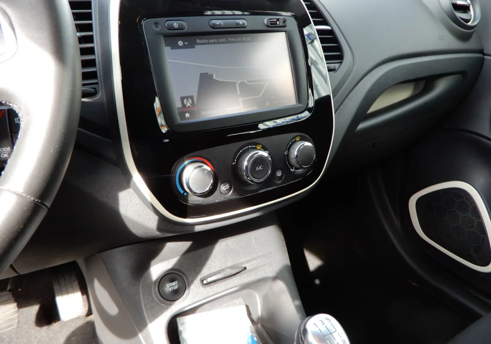 Tableau de bord du Renault Captur TCE 90 Business 2019, vue centrée sur la console avec écran tactile et levier de vitesses manuel.
