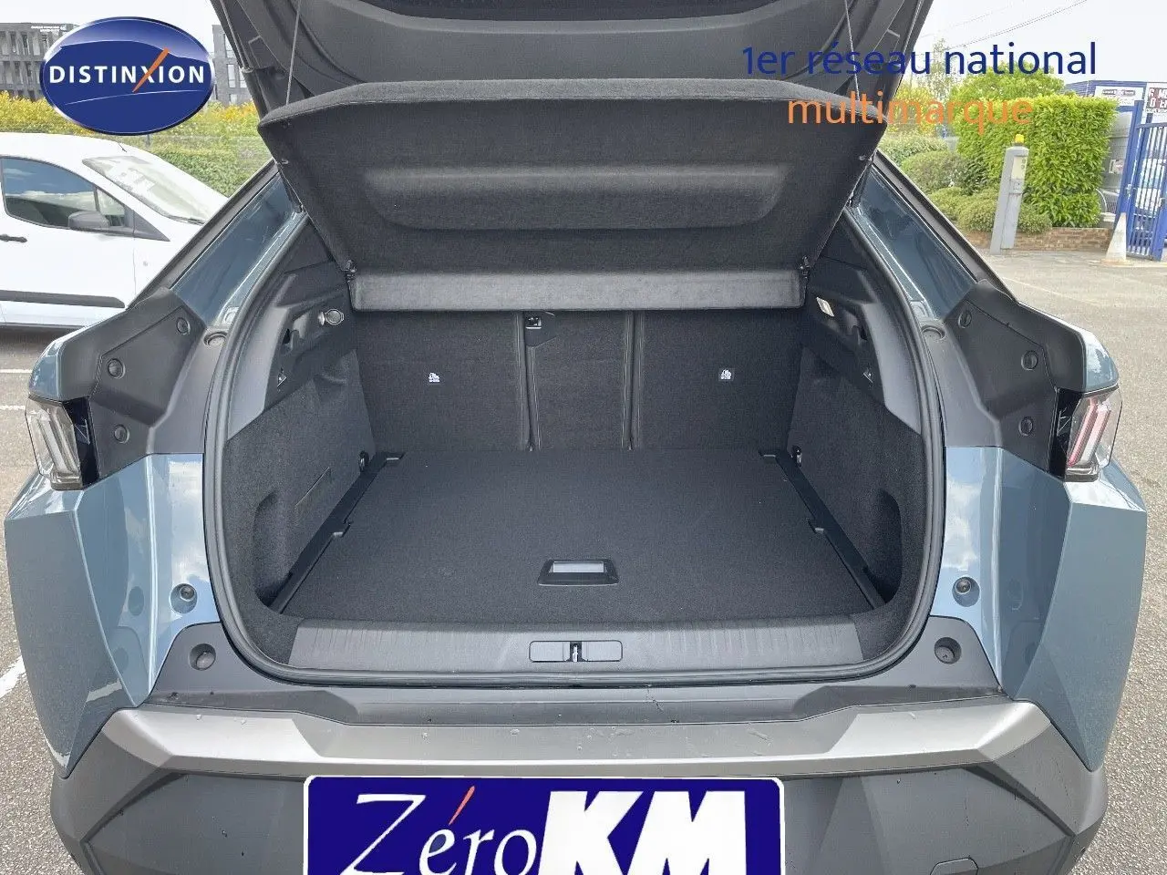 Coffre ouvert en vue arrière du Peugeot 3008 Hybrid bleu Ingaro Metal, montrant un espace de chargement spacieux.