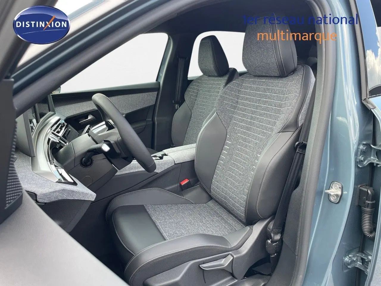 Vue intérieure côté conducteur du Peugeot 3008 Hybrid 2025 en bleu Ingaro Metal, sièges tissu et cuir noir avec surpiqûres.