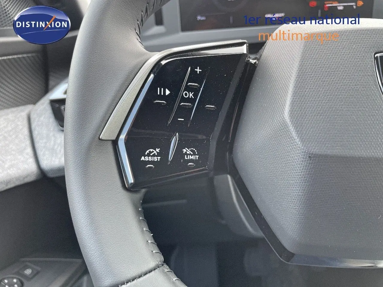 Gros plan sur les commandes au volant noir du Peugeot 3008 Hybrid 2025, avec boutons d'assistance et limitation de vitesse.