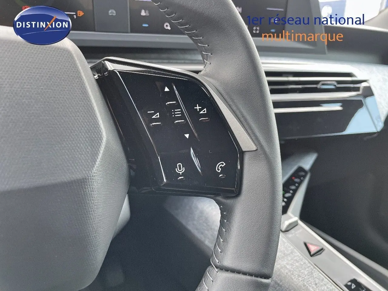 Gros plan sur le volant en cuir noir du Peugeot 3008 Hybrid 2025, avec commandes tactiles intégrées côté gauche.