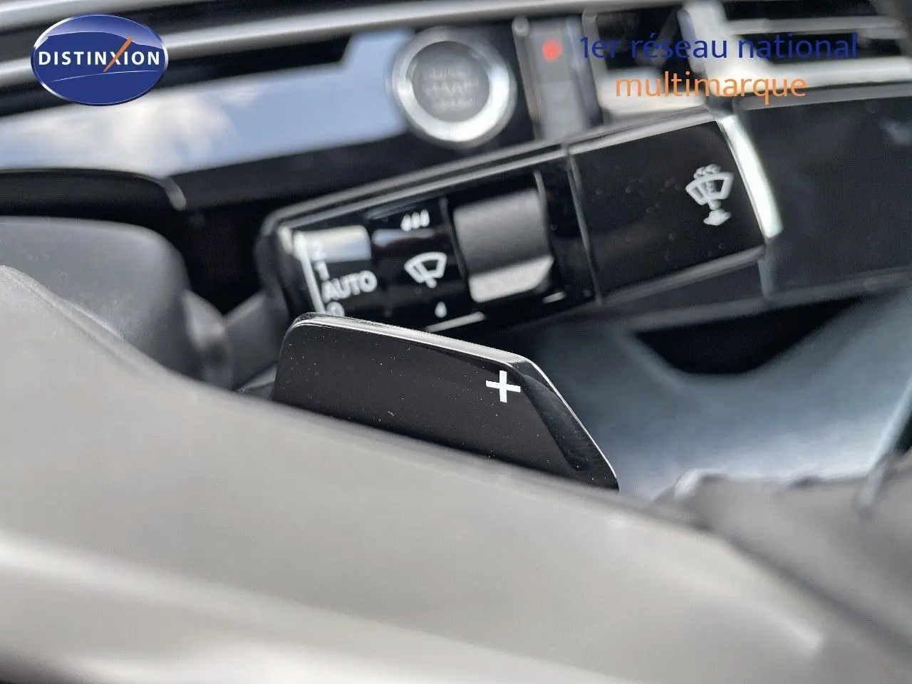 Gros plan sur la commande de palette de changement de vitesse "+" du Peugeot 3008 Hybrid 2025, intérieur moderne et épuré.
