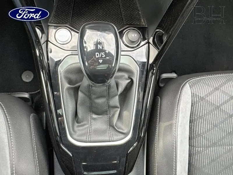 Le levier de vitesses automatique DSG7 en noir brillant avec soufflet cuir, vu en gros plan depuis l'intérieur du Volkswagen T-Roc.