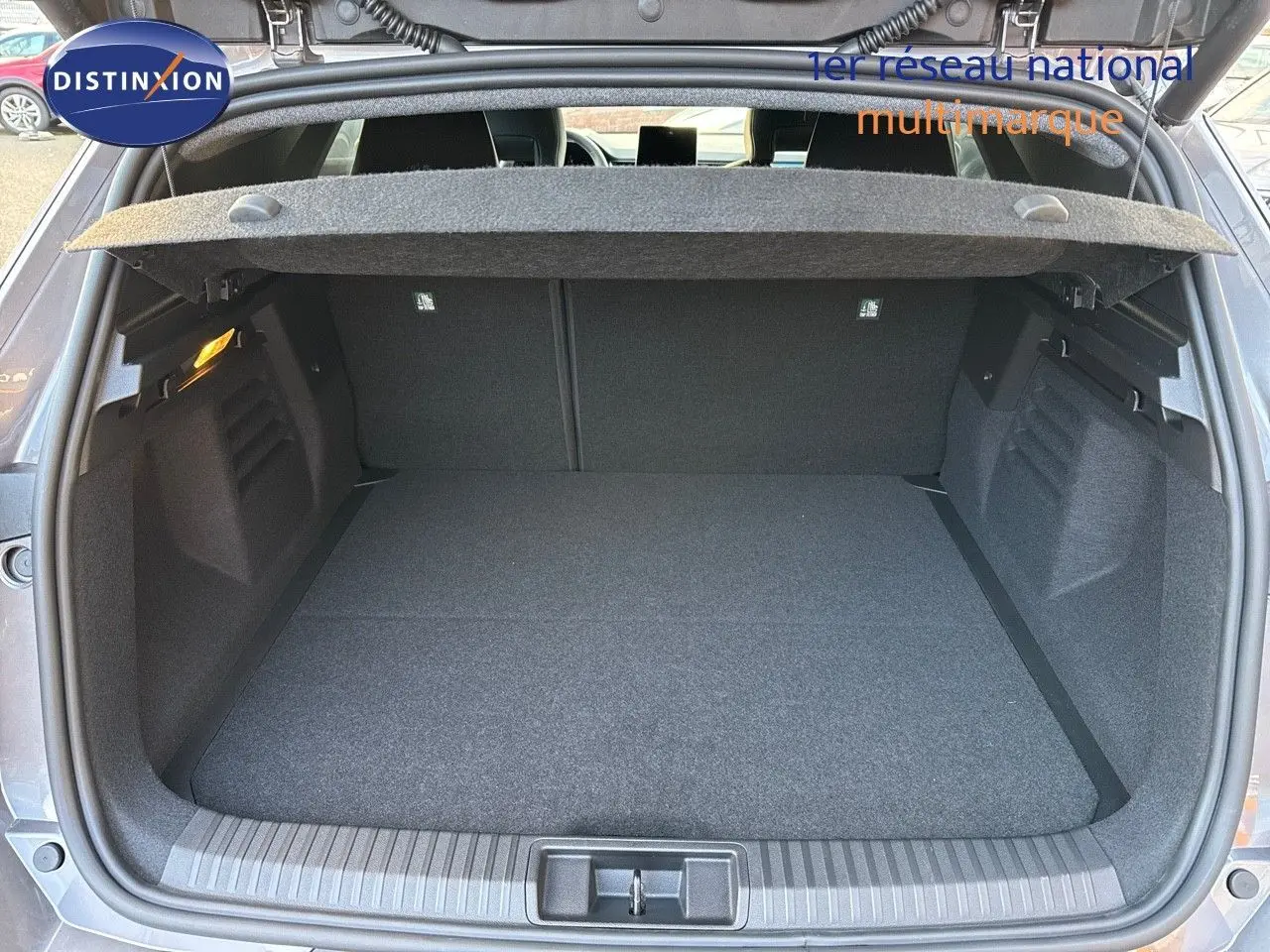 Coffre ouvert vu de l'arrière d'une Renault Symbioz gris cassiopée métal, espace de chargement propre et spacieux.