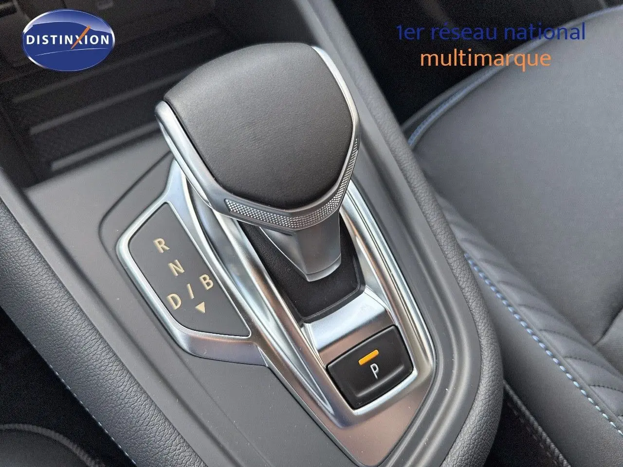 Gros plan sur la commande de boîte automatique noire et chrome du Renault Symbioz gris cassiopée métal, intérieur cuir noir.