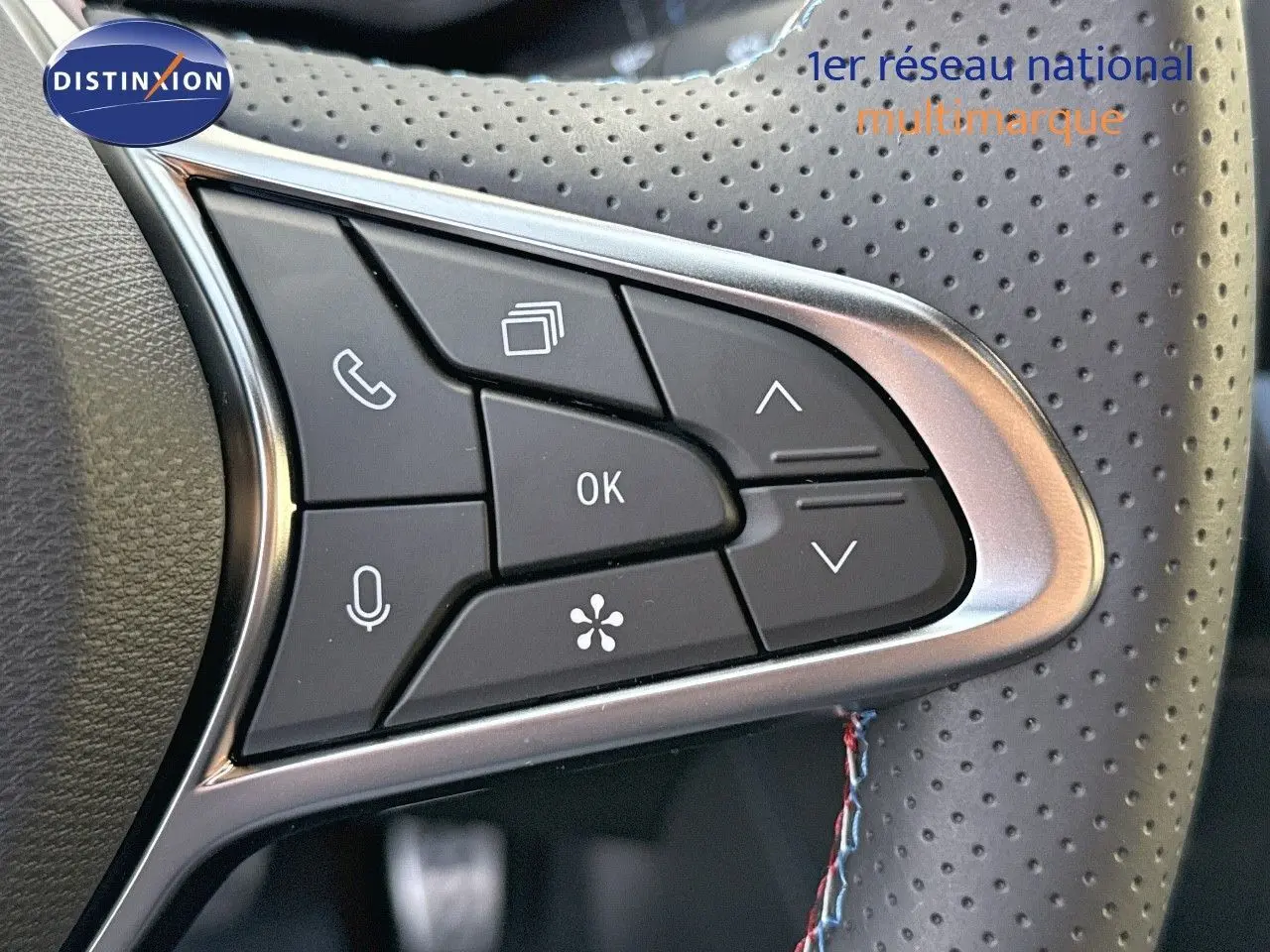 Gros plan sur les commandes multifonctions du volant en cuir perforé gris du Renault Symbioz 2024 finition Esprit Alpine.