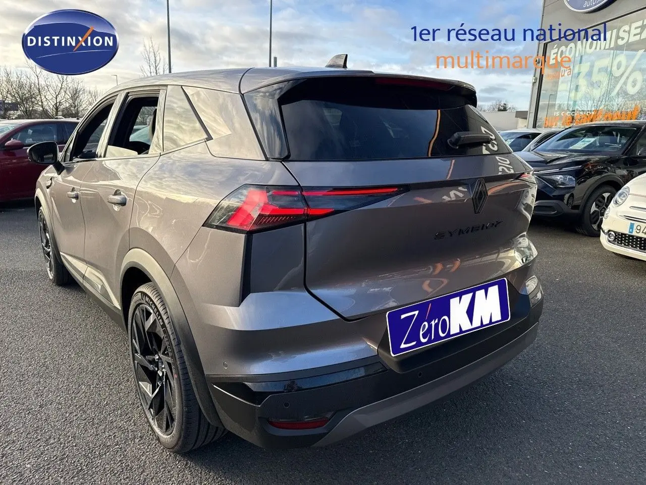 Vue 3/4 arrière droite du Renault SYMBIOZ gris cassiopée métal avec feux arrière LED et jantes noires en concession.