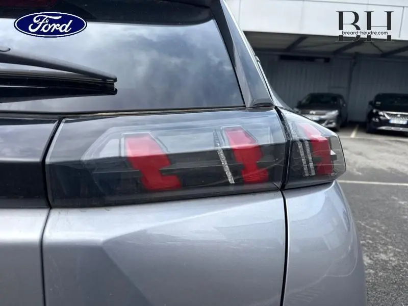 Gros plan sur le feu arrière droit d'un Peugeot 2008 gris Artense, soulignant son design moderne et ses LED rouges.