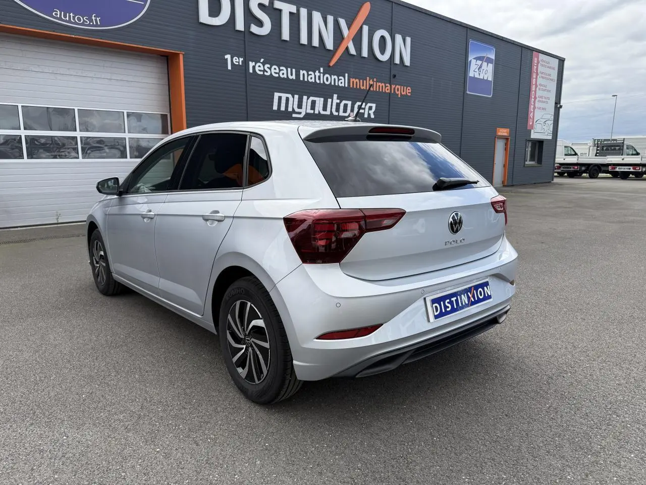 Volkswagen Polo gris reflet argent vue 3/4 arrière droit, avec vitres arrière surteintées et feux LED distinctifs.