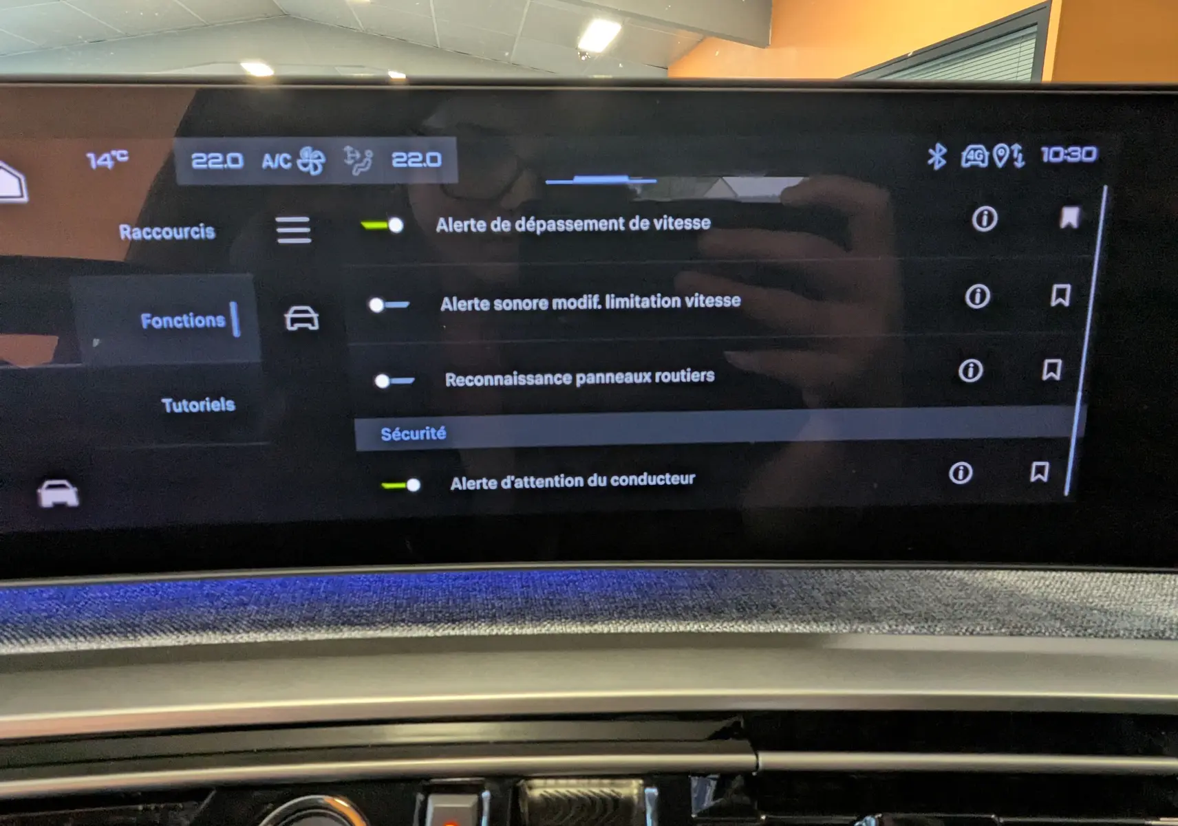 Vue rapprochée de l'écran tactile panoramique 21'' du Peugeot 3008 Hybrid noir, affichant les réglages de sécurité et climatisation.