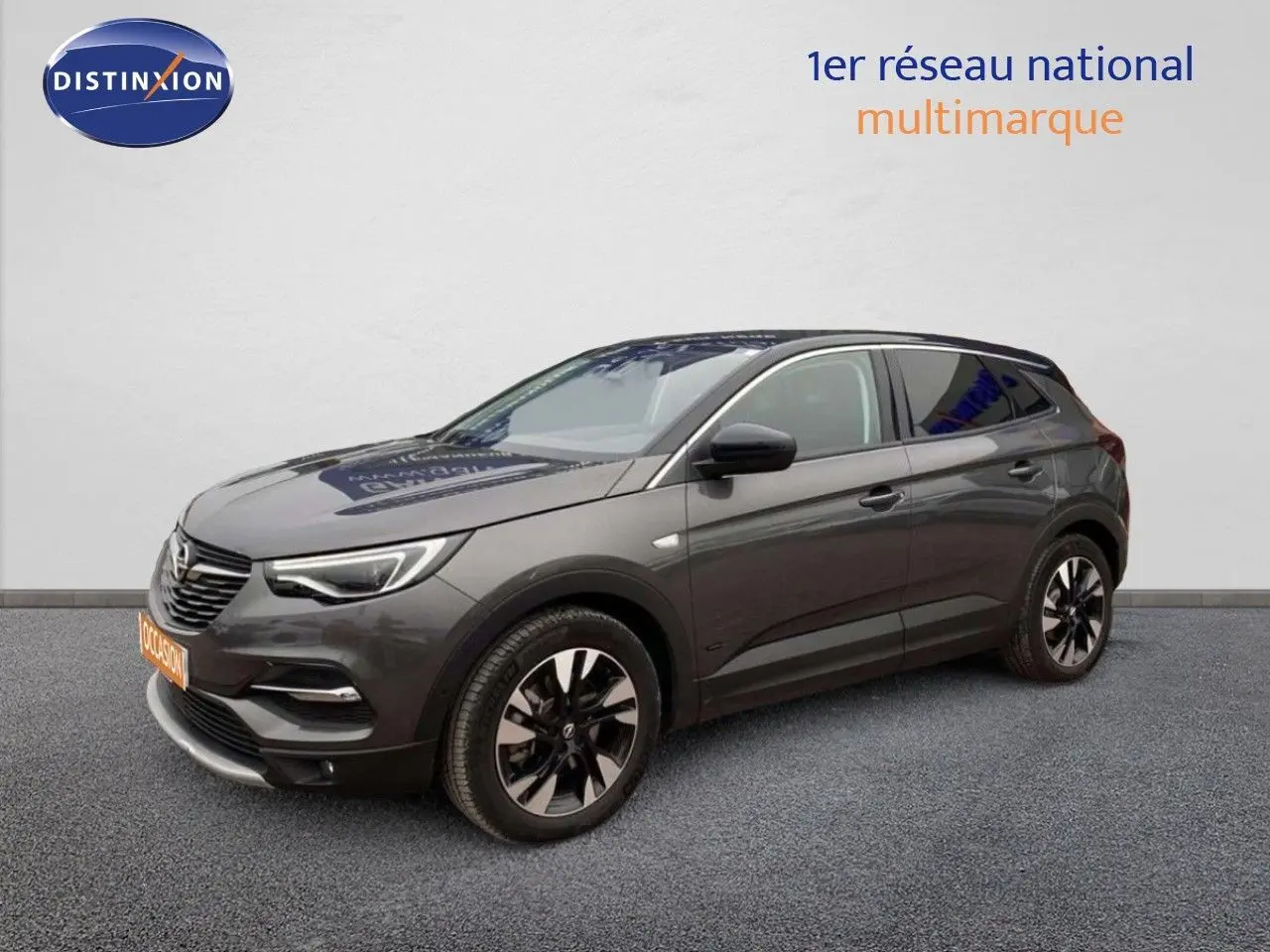 Opel Grandland X gris Moai métal en vue 3/4 avant droit, SUV hybride rechargeable avec jantes bicolores distinctives.