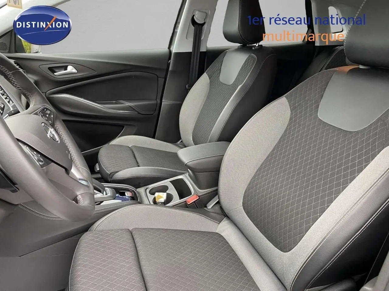 Intérieur avant de l'Opel Grandland X gris Moai Metal, sièges tissu et cuir noir avec console centrale visible.