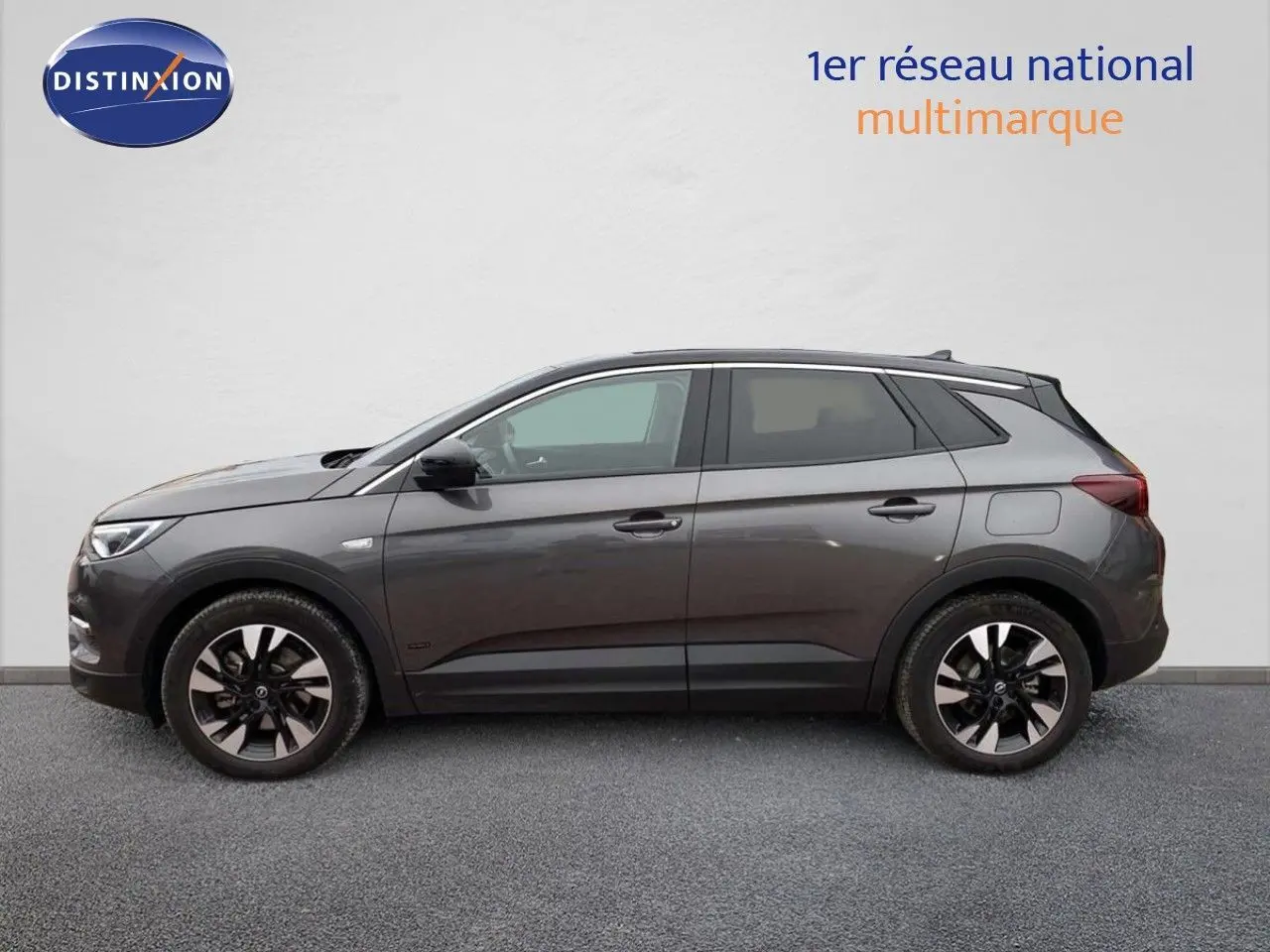 Profil côté gauche d'un Opel Grandland X gris Moai Metal hybride rechargeable avec jantes bicolores en alliage.