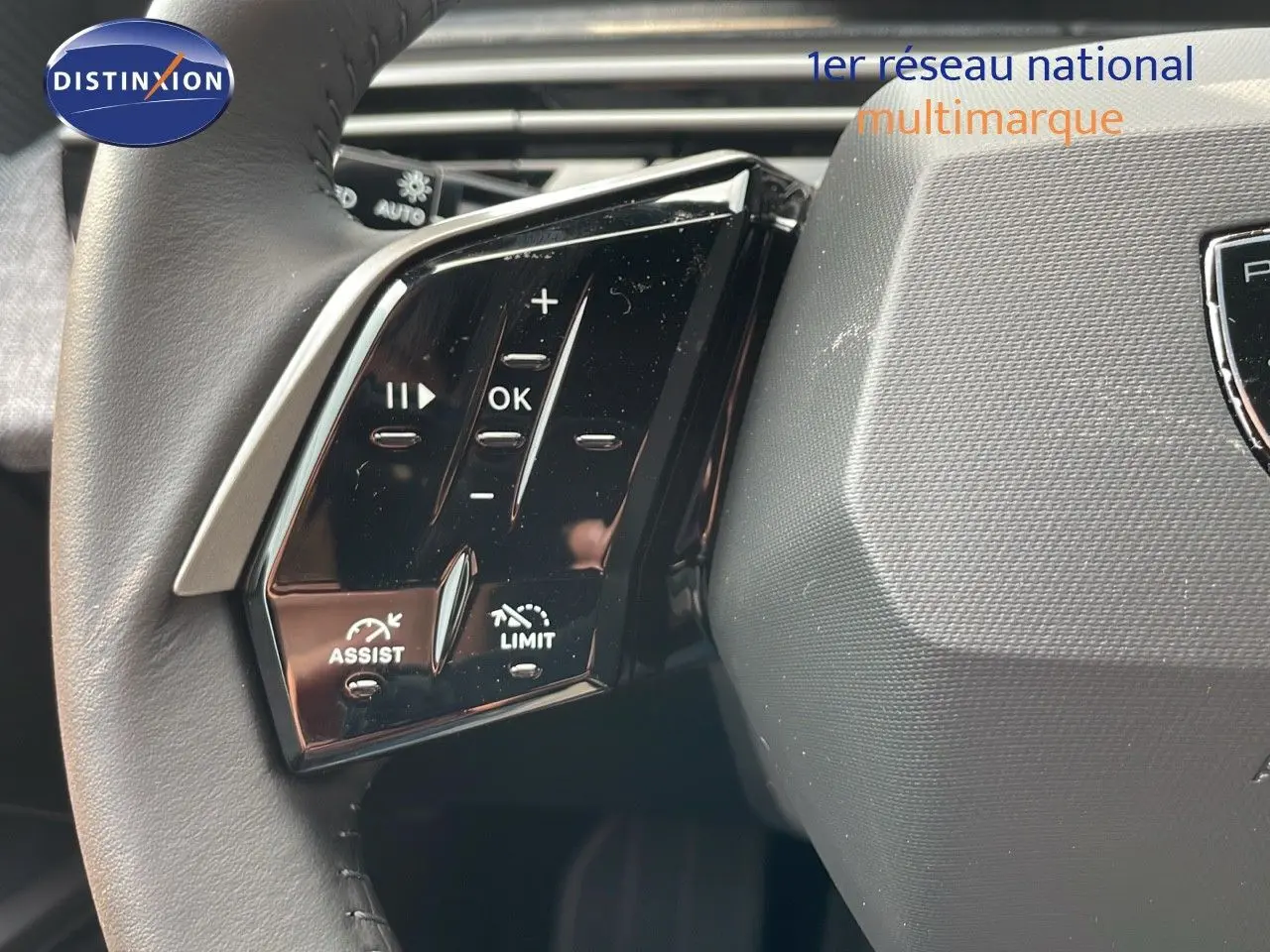 Gros plan sur les commandes gauche du volant cuir du Peugeot 3008 gris Artense, avec boutons d'assistance et limitation.