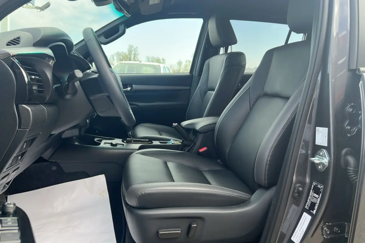 Intérieur du Toyota Hilux 2025 gris atlas, vue côté conducteur avec sièges en cuir noir et tableau de bord moderne.