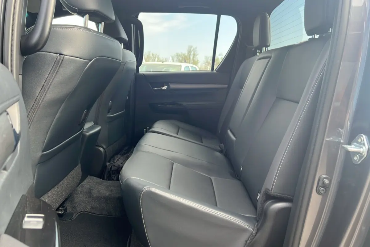 Vue intérieure côté droit sur la banquette arrière en cuir noir du Toyota Hilux 4x4 gris atlas 2025.