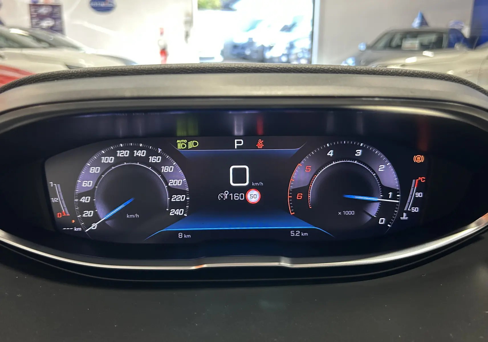 Tableau de bord numérique du Peugeot 5008 2024, affichant vitesse, régime moteur et indicateurs au repos.