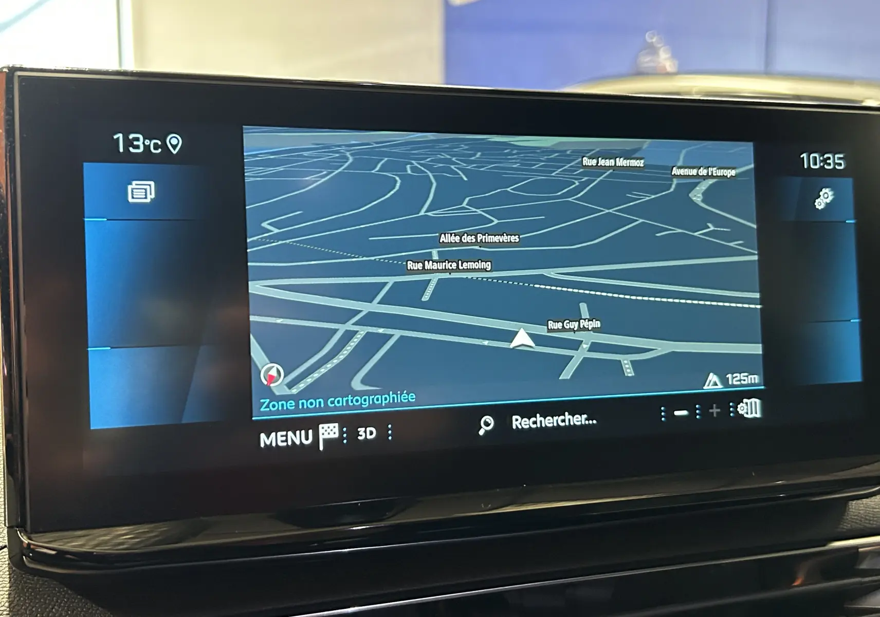 Écran tactile du système de navigation du Peugeot 5008 2024 affichant une carte en 3D avec température extérieure à 13°C.