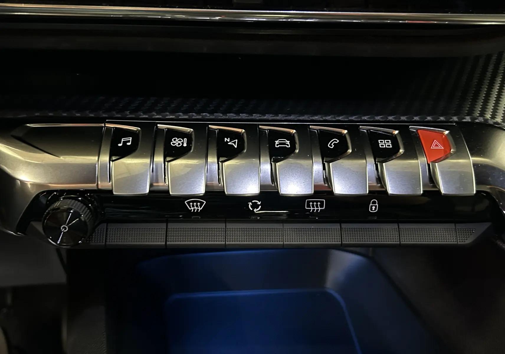 Gros plan sur la rangée de boutons métalliques et rouge d'alerte du tableau de bord du Peugeot 5008 Gris Platinium 2024.