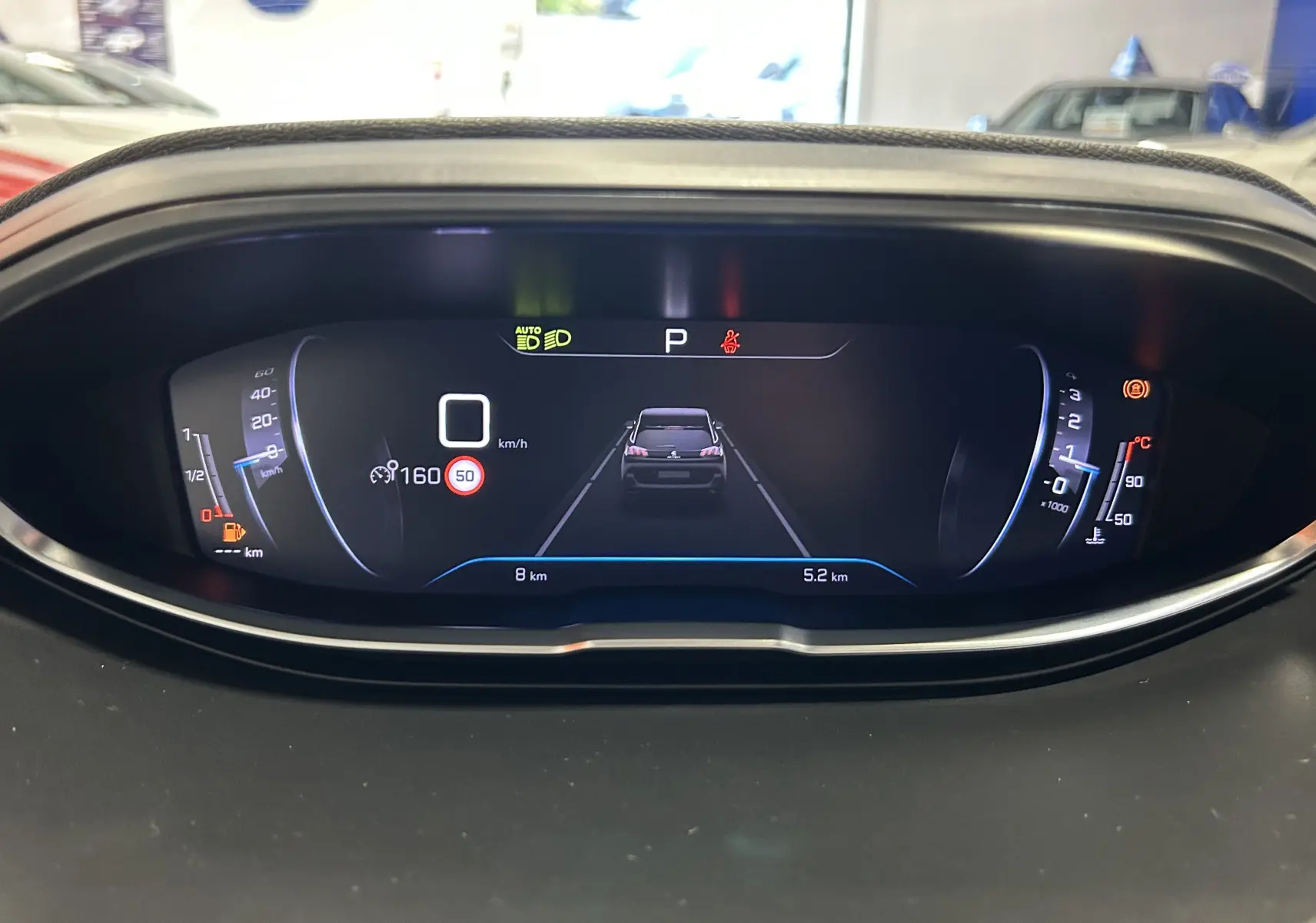 Tableau de bord numérique du Peugeot 5008 2024 affichant la vitesse, la consommation et l'assistance à la conduite.