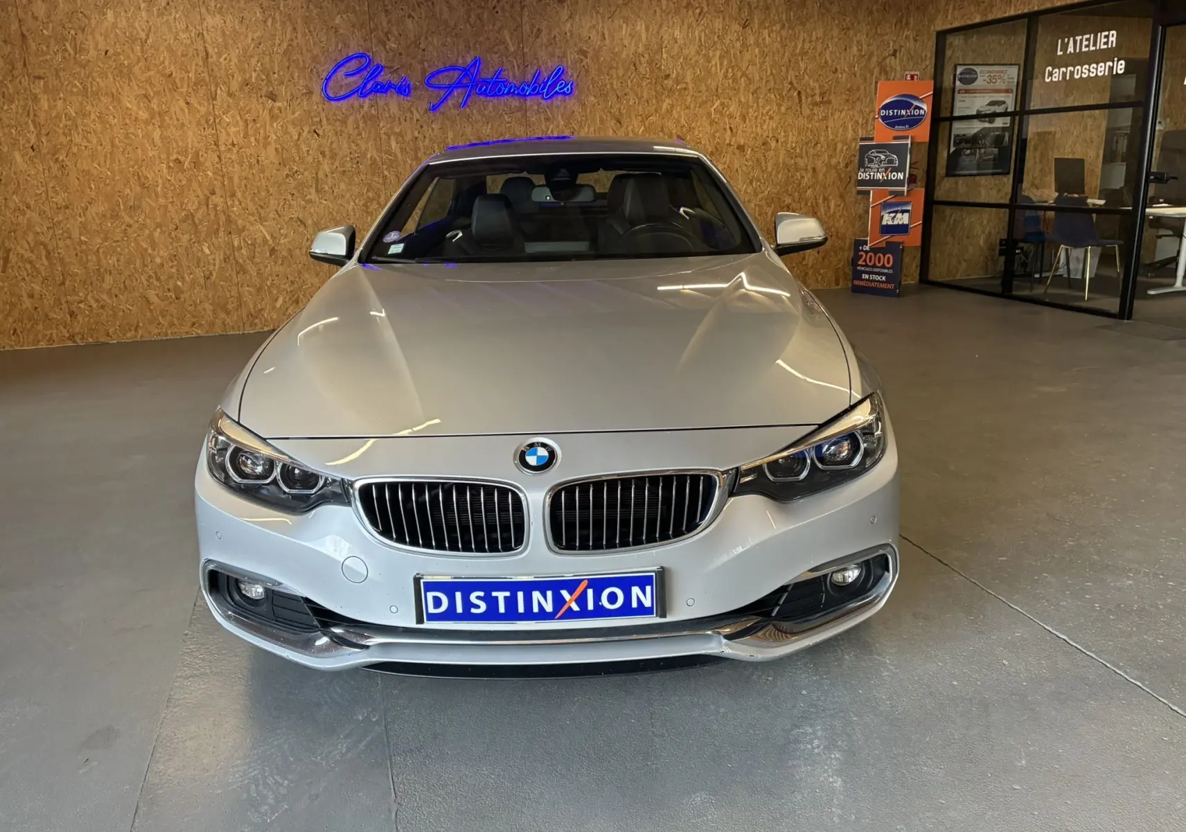 Vue frontale d'une BMW Série 4 Cabriolet F33 gris métallisé, avec calandre caractéristique et phares LED allumés.