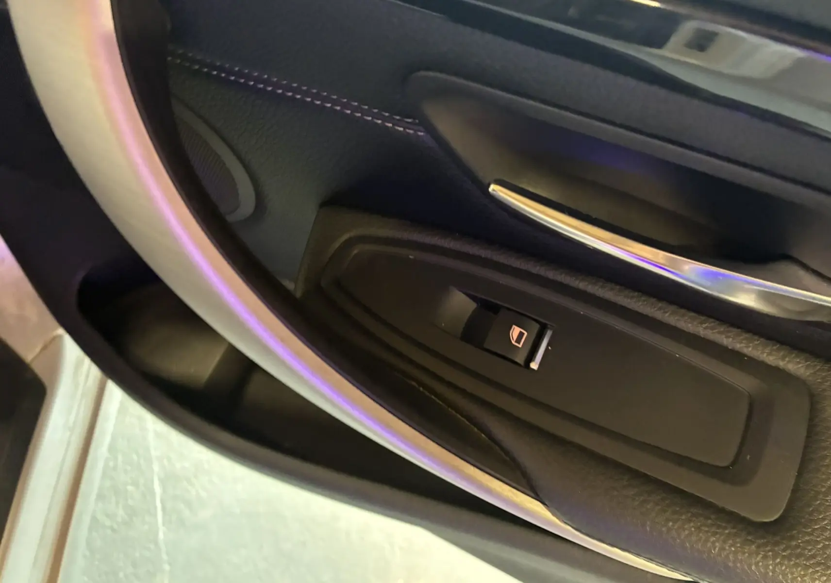 Gros plan sur le bouton de commande de la vitre côté gauche dans l'intérieur noir du BMW Série 4 Cabriolet gris 2019.