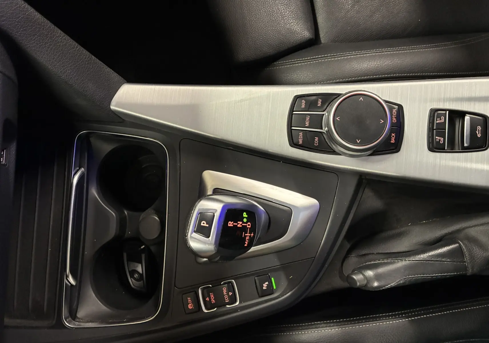 Vue rapprochée de la console centrale en aluminium brossé et cuir noir de la BMW Série 4 Cabriolet 420i 2019 avec levier de vitesses automatique.