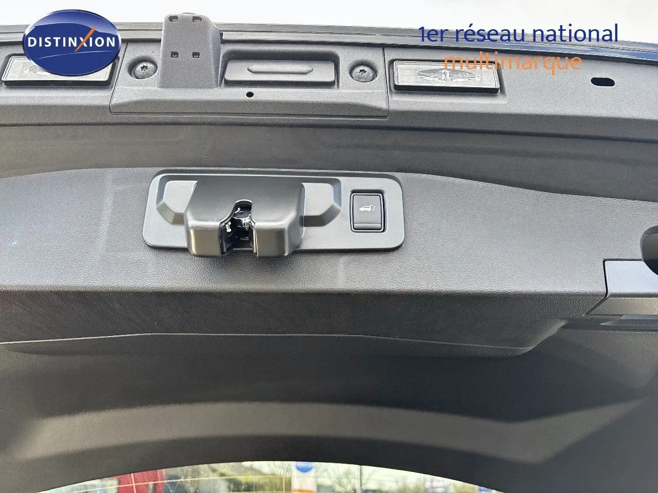 Gros plan sur le mécanisme d'ouverture du coffre du Renault Symbioz noir étoile métal, version hybride 2025.