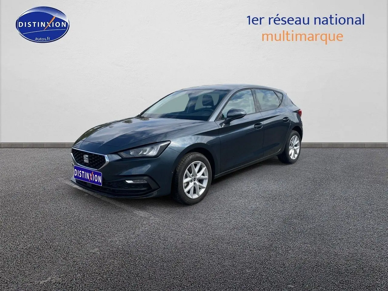 SEAT Leon IV gris magnétique métal vue 3/4 avant droit, mettant en valeur ses lignes dynamiques et jantes argentées.