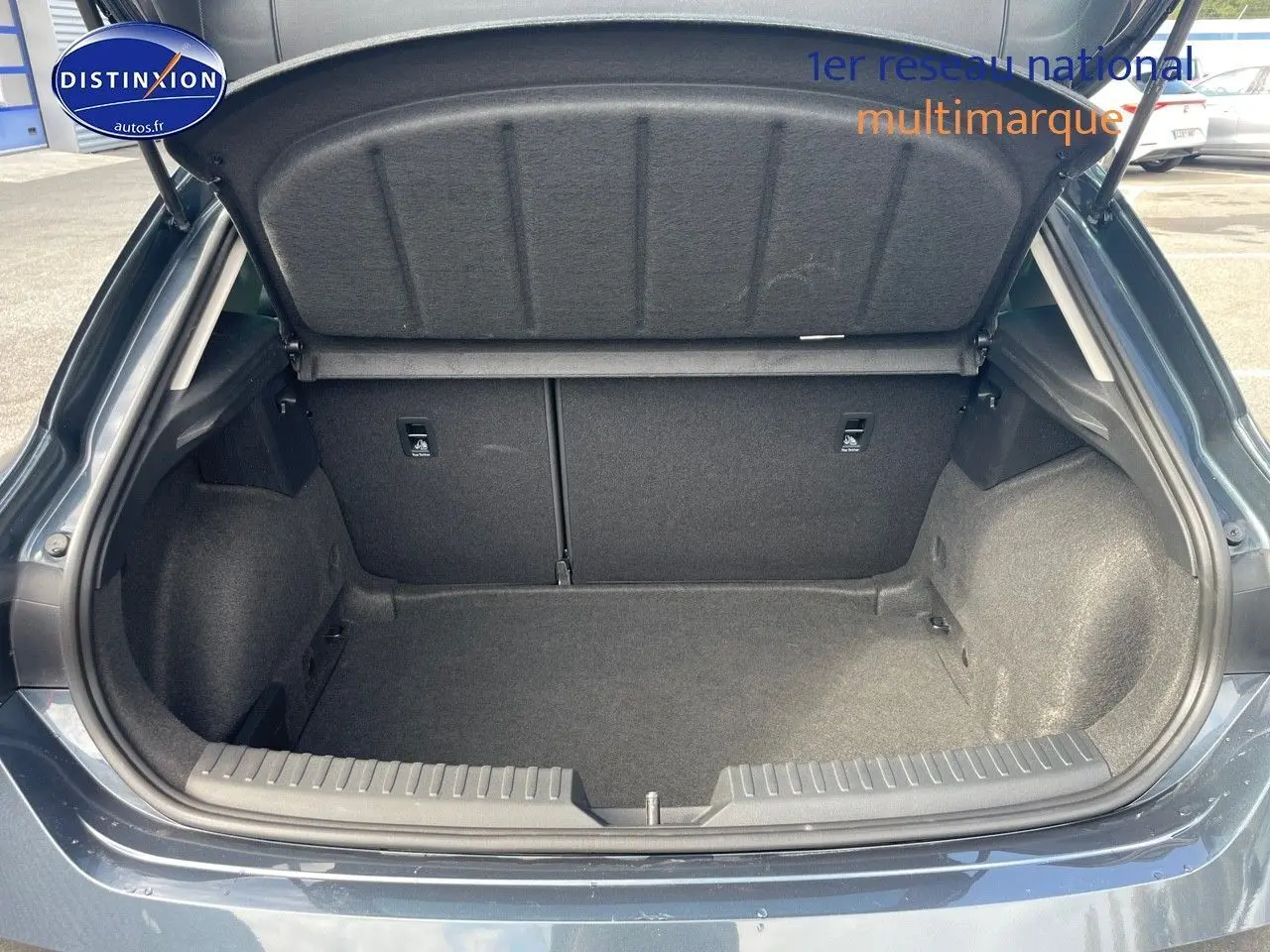 Coffre ouvert d'une SEAT LEON IV gris magnétique métal, montrant un espace de rangement propre et spacieux à l'arrière.