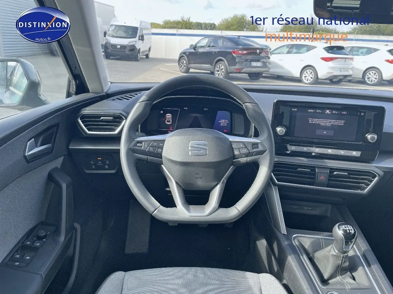 Vue intérieure centrée sur le volant et tableau de bord d'une SEAT Leon IV gris métallique avec boîte manuelle.