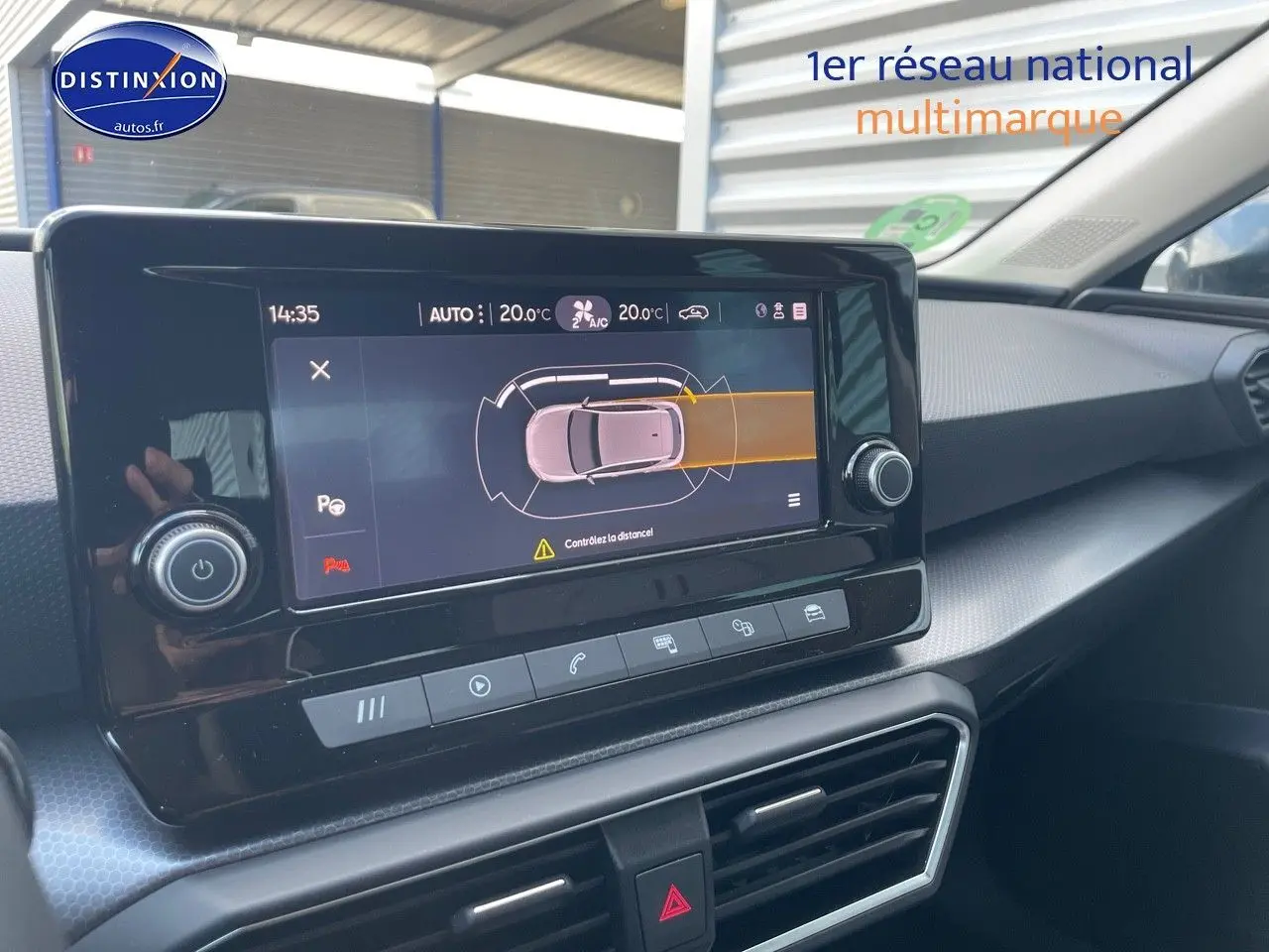 Vue rapprochée de l'écran tactile central du tableau de bord d'une SEAT LEON gris magnétique 2024, affichant l'aide au stationnement.