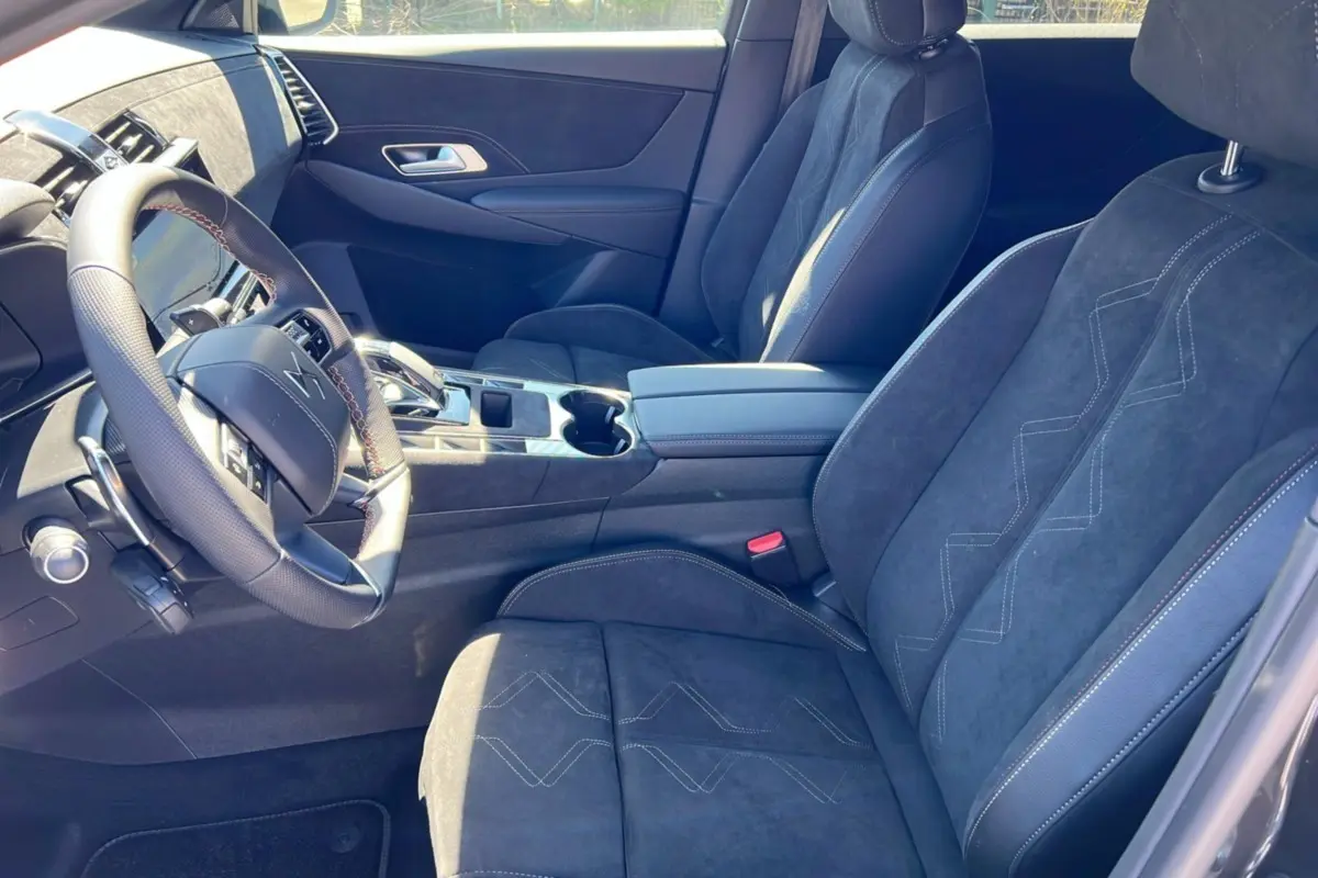 Intérieur du DS7 2025 en gris titane, vue côté conducteur montrant sièges en alcantara et volant multifonction.