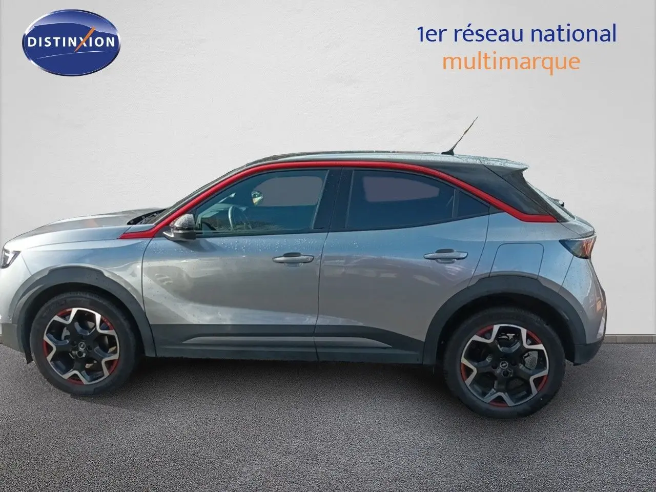 Profil droit d'un Opel Mokka GS Line 2022 gris quartz avec toit noir et détails rouges sur les jantes et la ligne de toit.