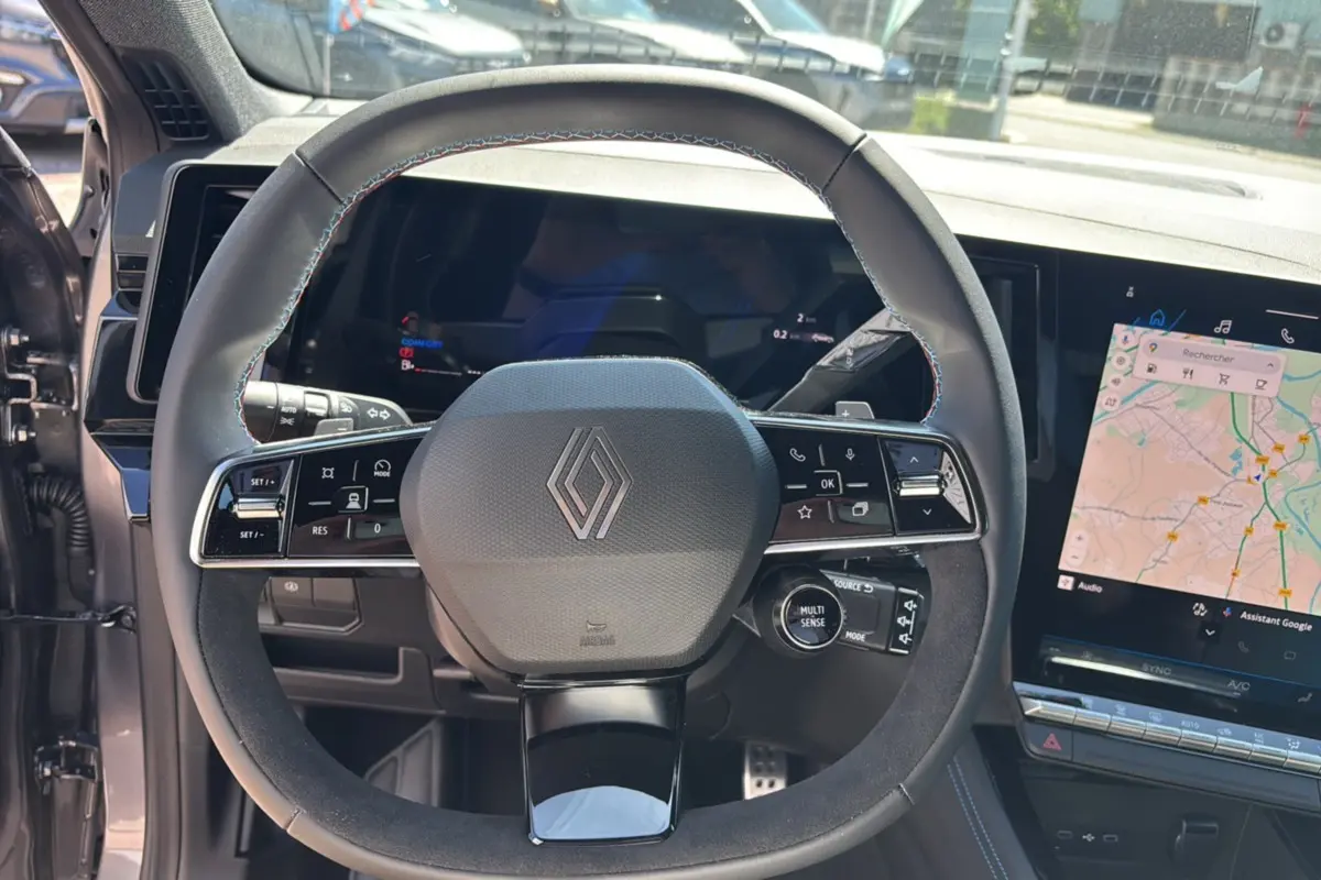 Vue rapprochée du volant multifonction du Renault Austral E-Tech 200 Esprit Alpine 2025 avec tableau de bord numérique et écran tactile.